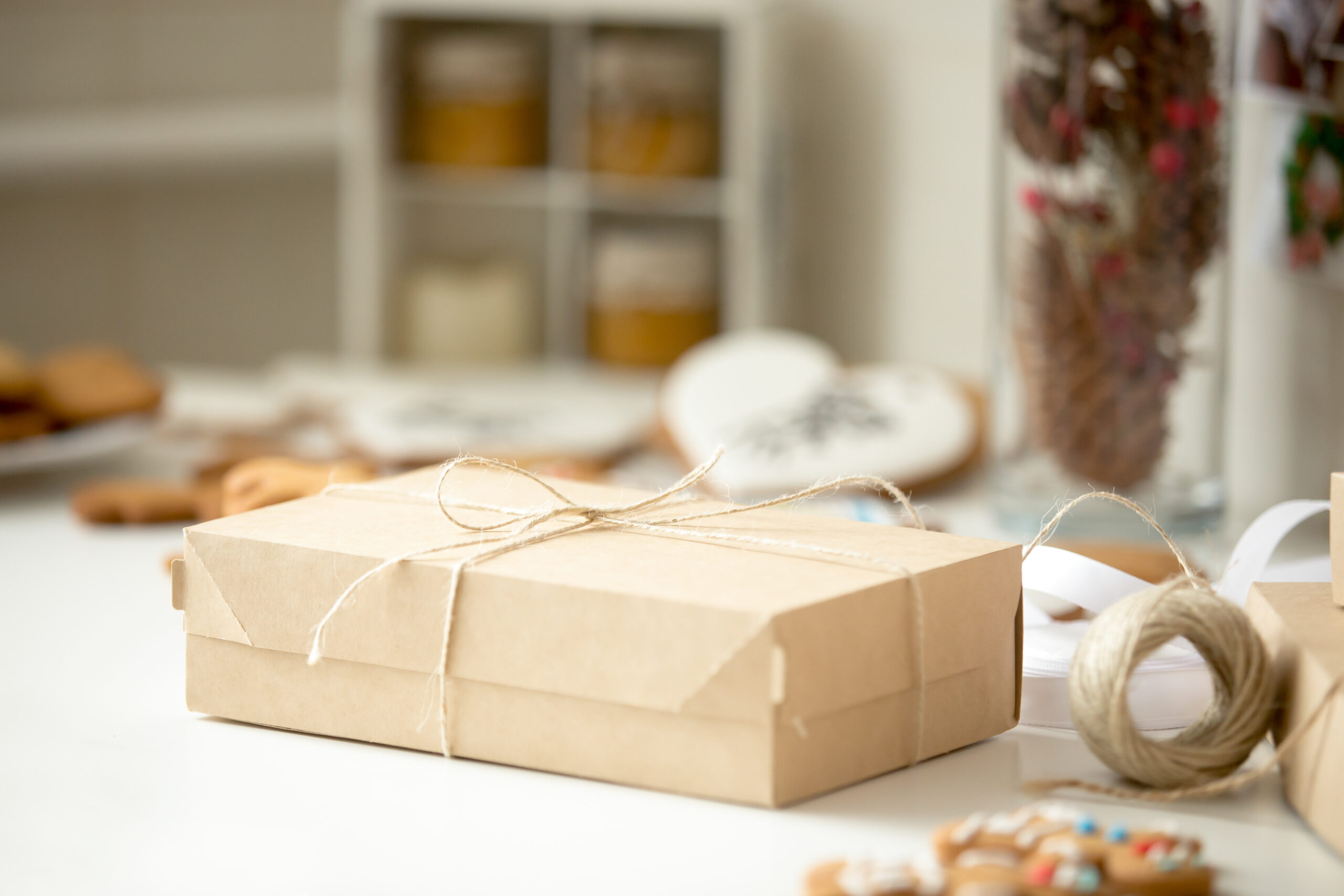 Cardboard box postal parcel wrapped in brown kraft paper tied with string - best packaging for baked goods
